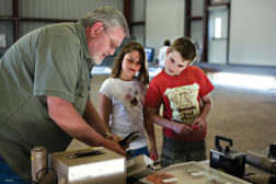 Marty Peifer shows a pair of children an air quality reading