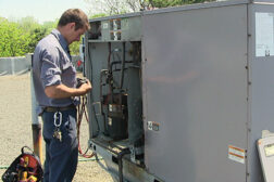 A technician from Flame Heating, Cooling, Plumbing, and Electrical, Warren, Mich., performs routine maintenance on a rooftop unit above the companyâs building.