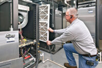 A service technician works on a geothermal system at Annett Nature Center in Indianola, Iowa. Horizontal loops were installed at a depth of about 15 feet for this project.