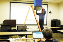 Steve Garifo, service technician, McKenneyâ??s Inc., Charlotte, North Carolina, checks the cfm while Raul Pena, controls specialist at McKenneys, operates the variable air volume (VAV) from a laptop computer.