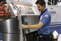 A service technician is recharges a small refrigeration unit with HFC-134a. Under an EPA proposal, the use of that refrigerant would not be allowed in similar equipment manufactured in 2016 and beyond.