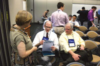 Kenneth Schultz, center, of Ingersoll Rand, consults notes while in conversation following his presentation at Purdue University on low-GWP refrigerants in elevated ambient conditions.