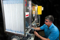 NREL engineer Eric Kozubal works on a first-generation prototype air conditioner that is predicted to save 40-80 percent of the energy used in a light commercial building, which would go a long way in achieving ZNE status.