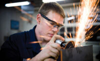 Airman 1st Class Jeremy Hamblin, 374th Maintenance Squadron metals technician, grinds on a sheet of metal that will be used to make a flange.