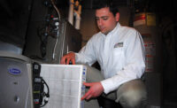 SELLING HOME PERFORMANCE: Ian McNett of Lakeside Service Co. in Brighton, Michigan, installs a filter during a home-performance sale.