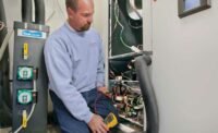 ENHANCED EFFICIENCY: Anthony Sherman, owner of Sherman Co. LLC in Adel, Iowa, checks a 5.5-ton Modine Geothermal unit; one of two similar units at the museum.