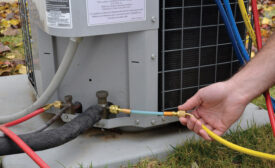 A technician adds a refrigerant sealant to the suction side of a residential air conditioning unit. Photo courtesy of Nu-Calgon