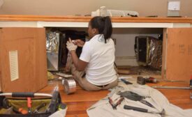 A Minnick’s employee applies duct-sealing tape for a customer.