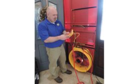 Conducting a blower door test to determine leakage.