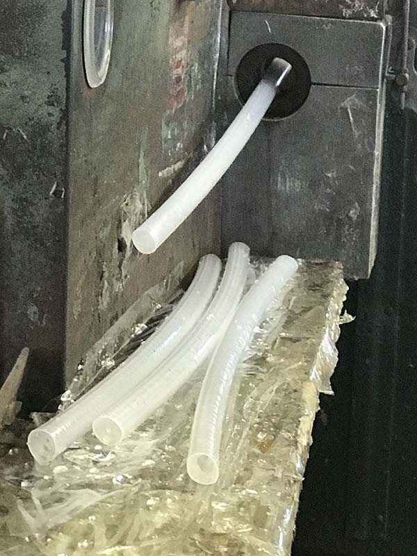 LDPE tubing is extruded out of a machine at Atlantis Plastics Company.