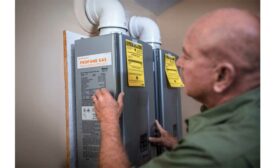 A technician installs a propane-fueled tankless water heater.