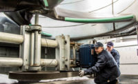 Technicians inspect a belt.